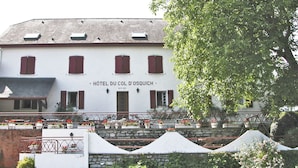 A hotel with a white facade, red shutters, and a sign reading "Hôtel du Coll d'Osquich". - Hôtel et Restaurant du Col Osquich (Musculdy)