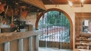 A restaurant interior with a checkered floor, wooden ceiling beams, and a view through an arched window. - Hôtel et Restaurant du Col Osquich (Musculdy)