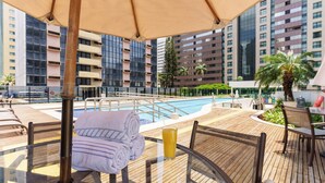A rooftop pool area with a glass table, chairs, and a towel. - Athos Bulcão Hplus Executive (Brasília)