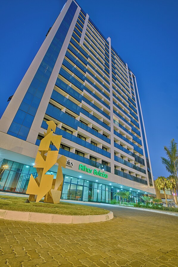 A high-rise hotel with a modern design, featuring a prominent vertical structure and a large glass facade. - Athos Bulcão Hplus Executive (Brasília)