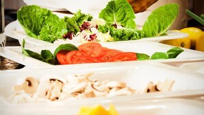 A salad with various vegetables and a plate of sliced mushrooms. - Hotel Restaurant Jagdhof (Steinhagen)
