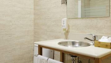 A modern bathroom with a toilet, sink, and mirror.