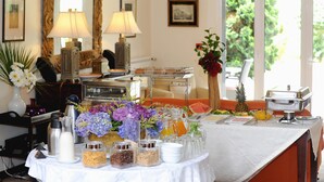 Ein Frühstücksbuffet mit verschiedenen Speisen, Beilagen und einer Kaffeestation.