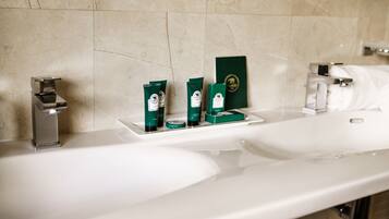 Une salle de bain avec deux lavabos, un miroir et des articles de toilette posés sur le comptoir.