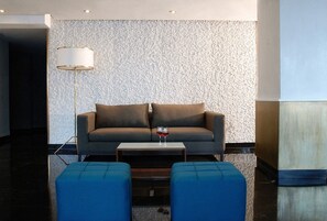 Una sala de estar moderna con un sofá, una mesa de centro y una lámpara de pie.