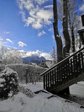 A snow-covered outdoor area with a wooden staircase, trees, and mountains in the background. - Czarny Potok Wellness & Spa Zakopane Centrum (Zakopane)