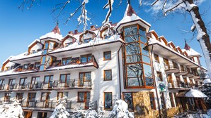 A multi-story hotel with balconies, large windows, and snow-covered surroundings. - Hotel Litwor (Zakopane)