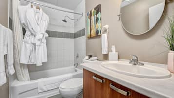 A modern bathroom with a bathtub, toilet, and sink.