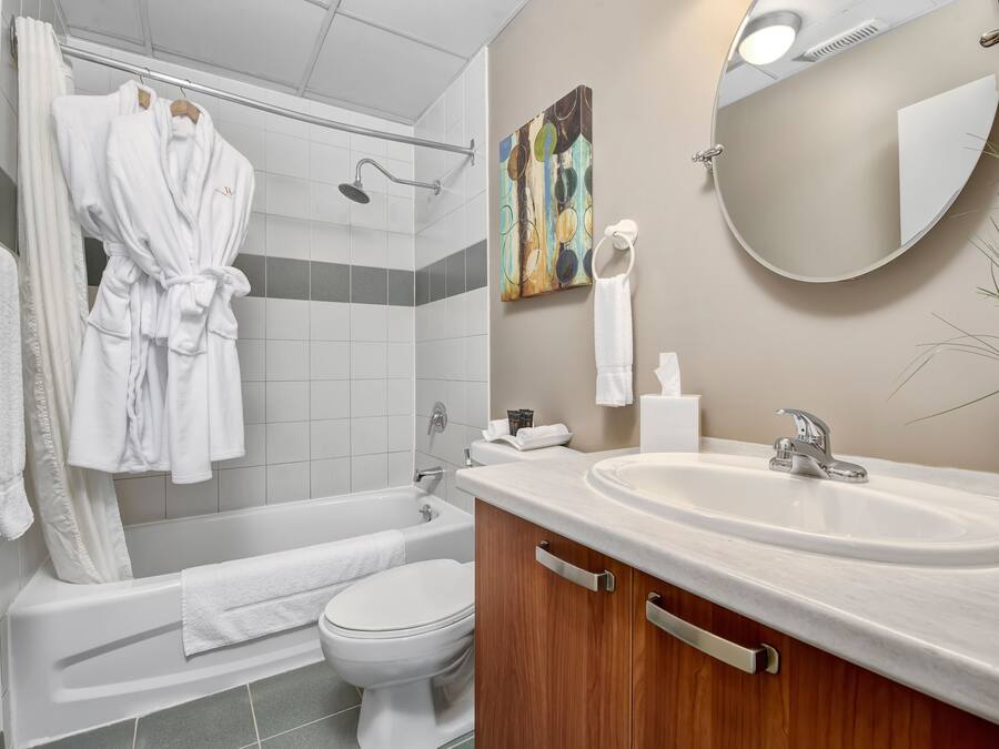 A modern bathroom with a bathtub, toilet, and sink.