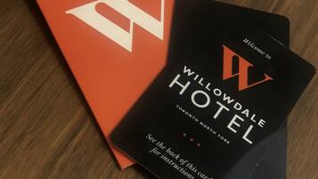 Um livreto vermelho com uma letra 'W' branca grande e um livreto preto com a marca do hotel e instruções.