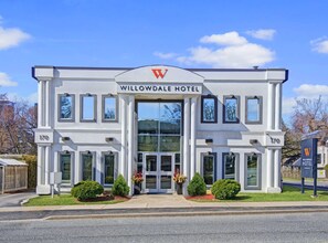 The exterior of the Willowdale Hotel, featuring a symmetrical facade with a central entrance, large windows, and a prominent 'W' logo above the entrance. - Willowdale Hotel Toronto North York (Toronto)