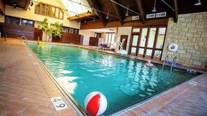 An indoor swimming pool with clear water, a lifeguard chair, and a lifebuoy on the wall. - Pere Marquette Lodge & Conference Ctr. (Grafton)
