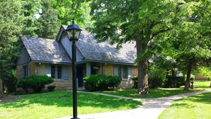 A stone building with a sloped roof, a pathway leading to the entrance, and a street lamp. - Pere Marquette Lodge & Conference Ctr. (Grafton)