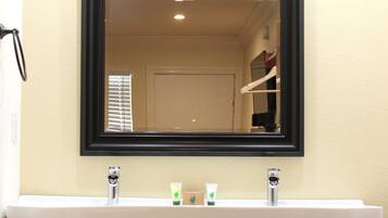 A bathroom with a white sink, black cabinets, and a large mirror above the sink.