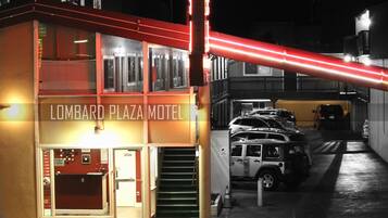 Un edificio con un letrero que dice "Lombard Plaza Motel". Hay varios coches estacionados frente al edificio.
