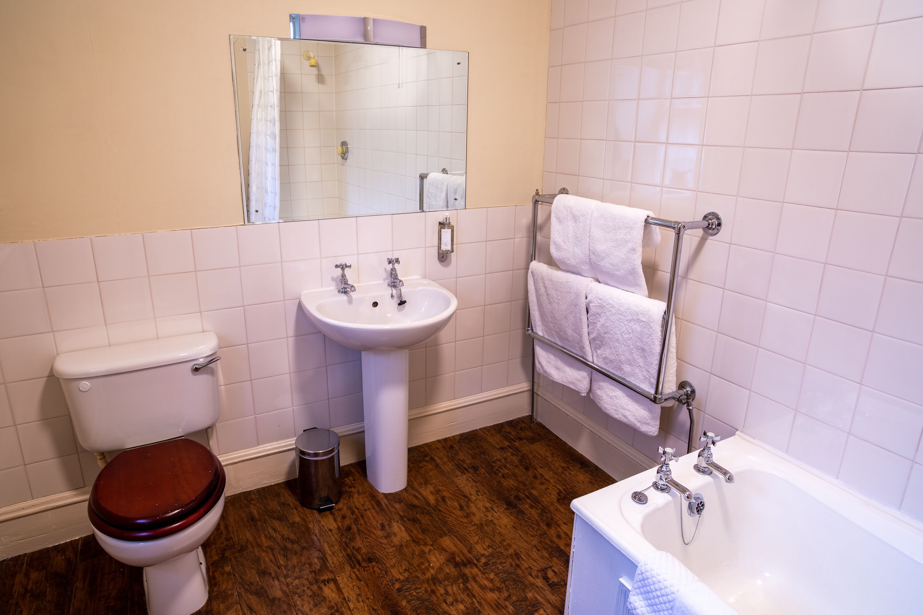 Et badeværelse med toilet, vask og badekar.