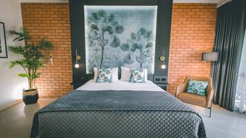 Een moderne slaapkamer met een groot bed, een potplant, een bank en een groot raam met uitzicht op palmbomen.