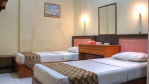 Quarto de hotel com duas camas de solteiro, uma cômoda de madeira, um espelho e um quadro na parede.