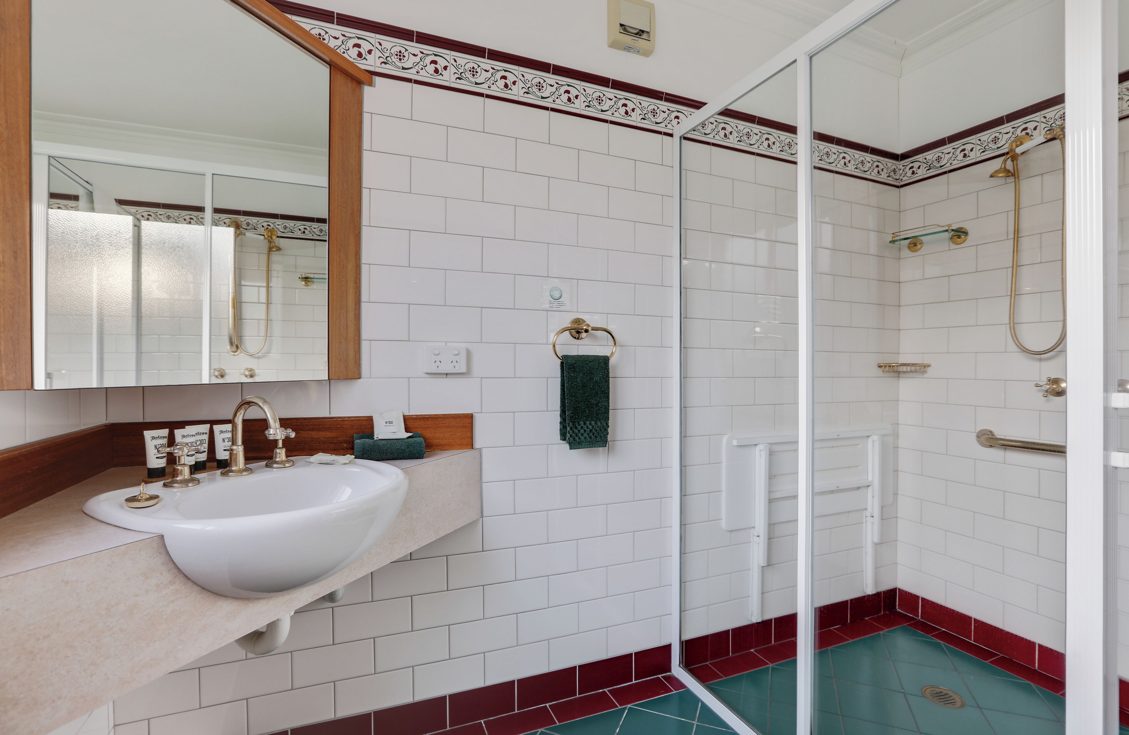 A bathroom with a white sink, mirror, and shower.