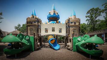 Explore a whimsical castle-themed play area with a central slide and two climbing structures.
