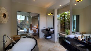 A modern bathroom with a large bathtub, a separate shower area, and a vanity with a sink and mirror. - Villa Toraja by Lifestyle Retreats (Canggu)