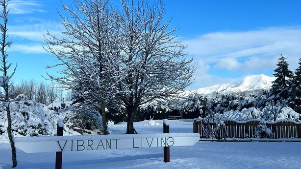A snow-covered landscape with a sign that reads "VIBRANT LIVING". - Vibrant Living Retreat (Hanmer Springs)