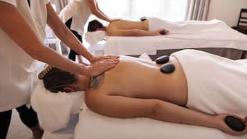 A massage therapy room with multiple clients receiving back massages.