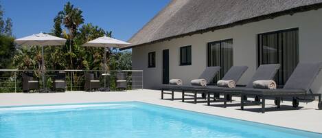 Piscina externa, guarda-sóis, espreguiçadeiras