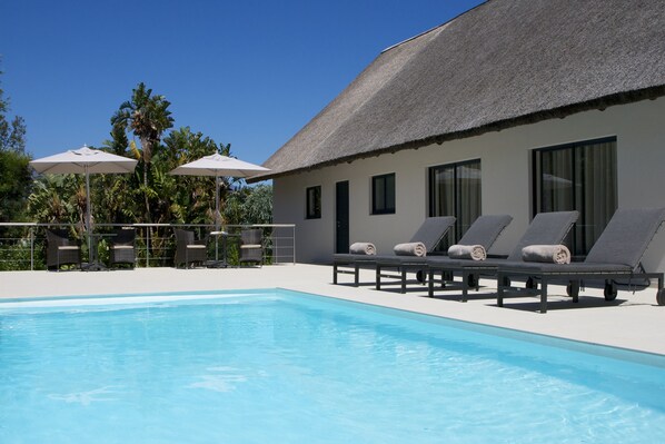 Piscina externa, guarda-sóis, espreguiçadeiras