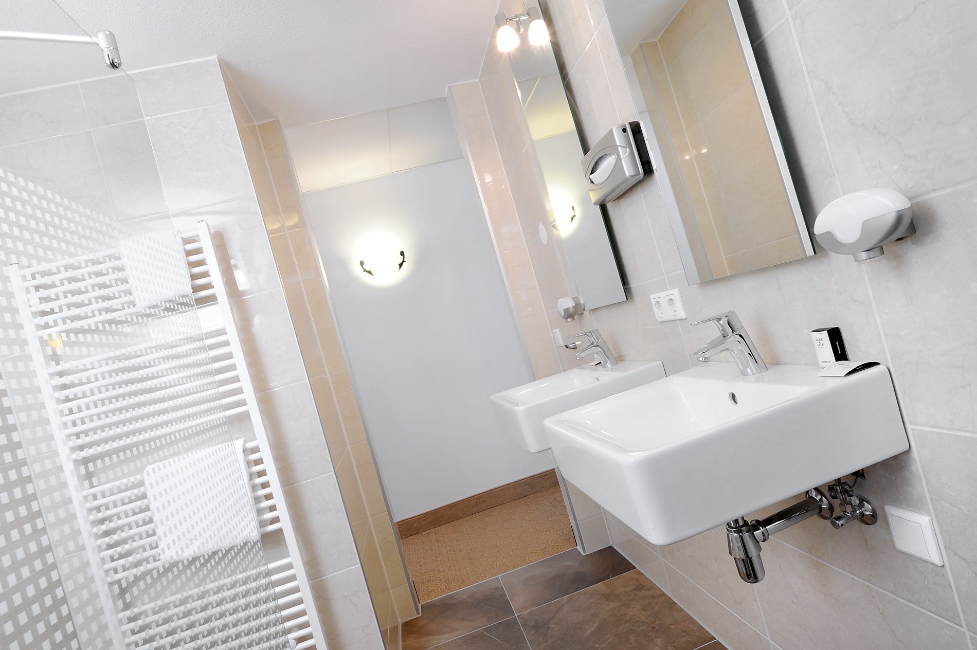 Ein modernes Badezimmer mit einem großen, weißen Waschbecken, einem Spiegel und einer Duschkabine mit Glastür.