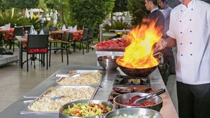 A buffet setup with various food items and a chef cooking with a flame. - Özkaymak Select Hotel - Ultra All Inclusive  (Alanya)