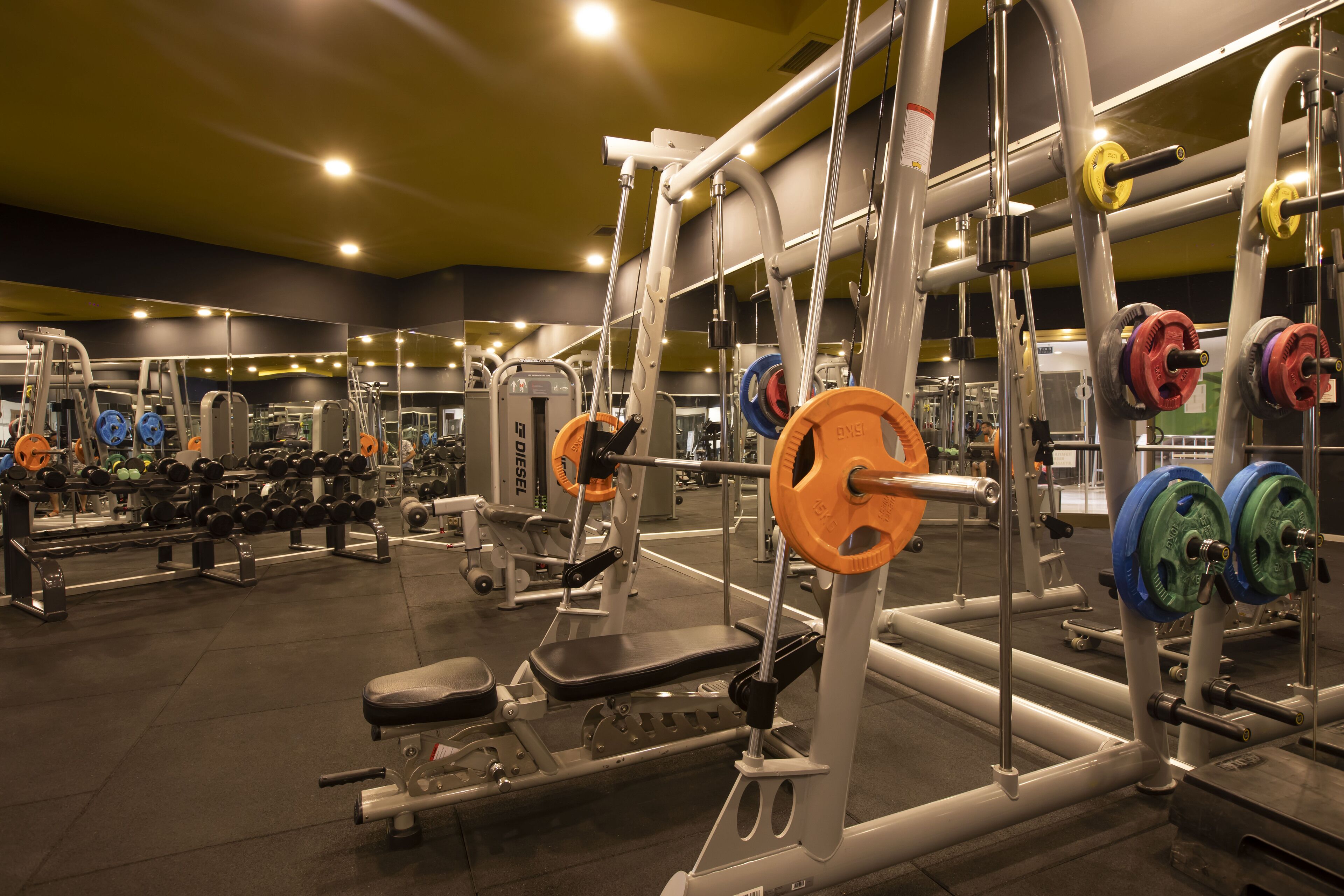 A gym with various weightlifting equipment and machines.