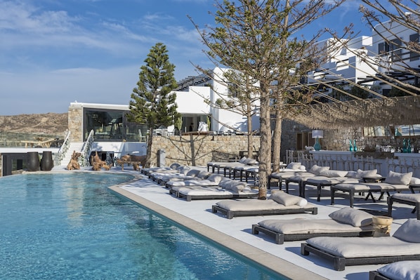 Relax by the pool surrounded by lush trees and a modern architectural design.