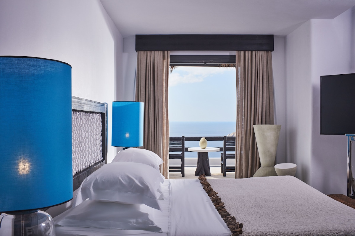 Una habitación de hotel con cama, televisión, mesa y silla.