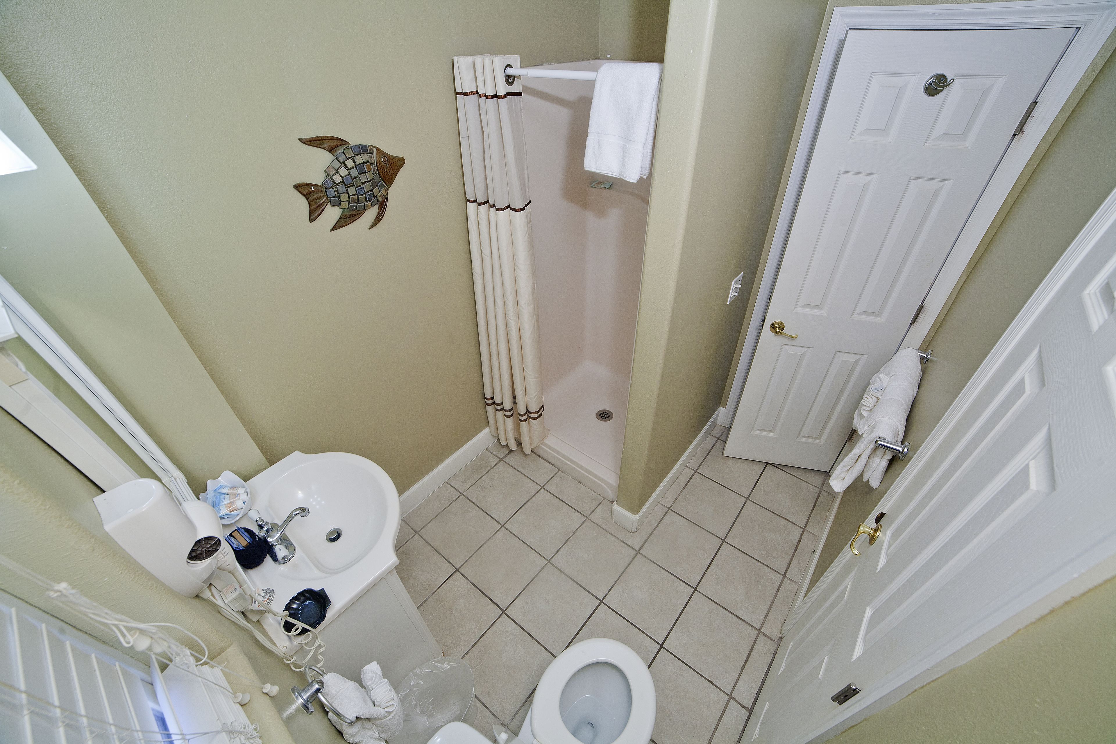 Un baño con lavamanos, inodoro y ducha.