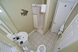 A bathroom with a sink, toilet, and shower.