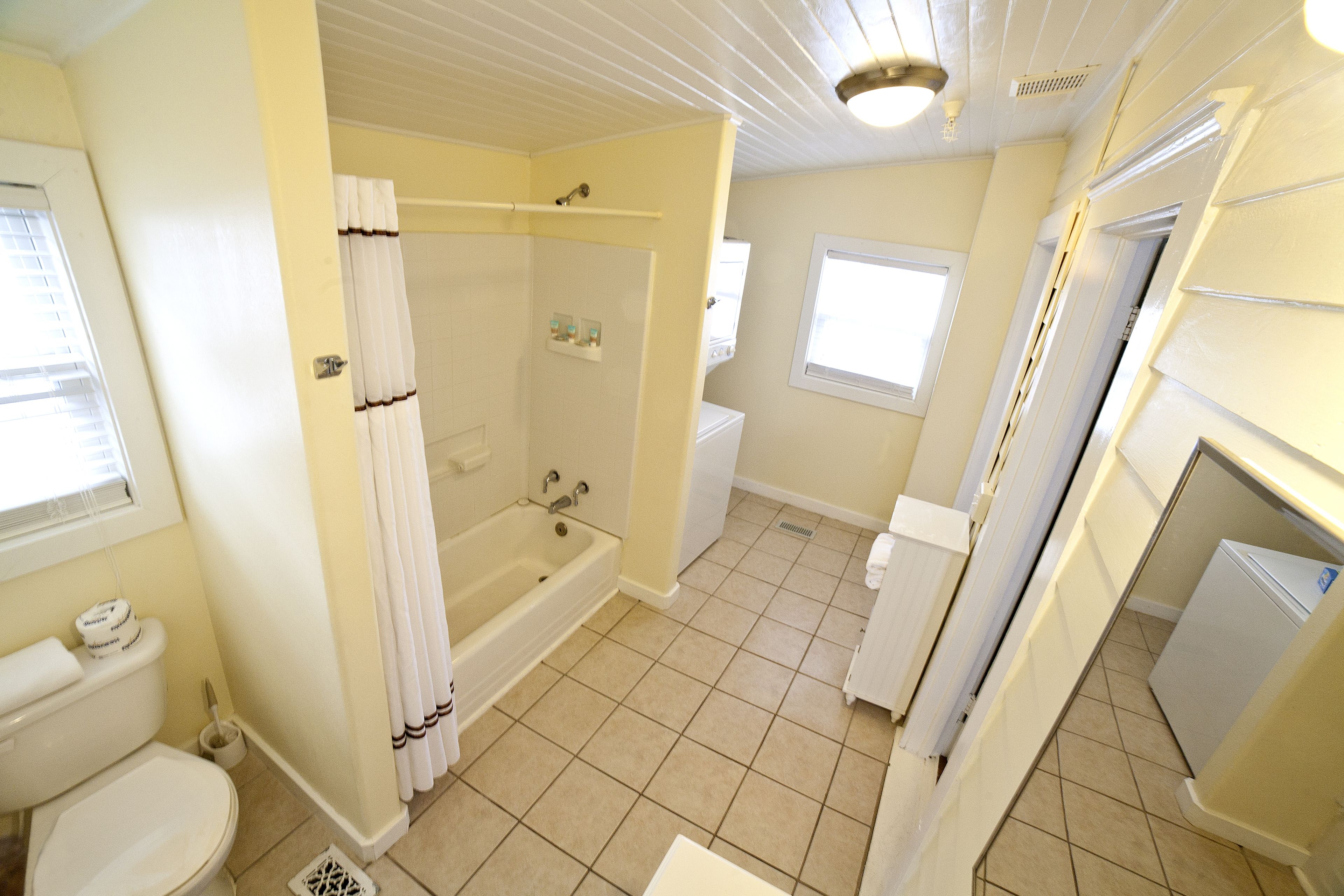 A bathroom with a bathtub, toilet, and sink.