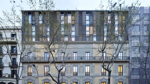 A multi-story building with a classic architectural style, featuring a central entrance with a canopy and multiple balconies. - Hotel Vincci Gala (Barcelona)