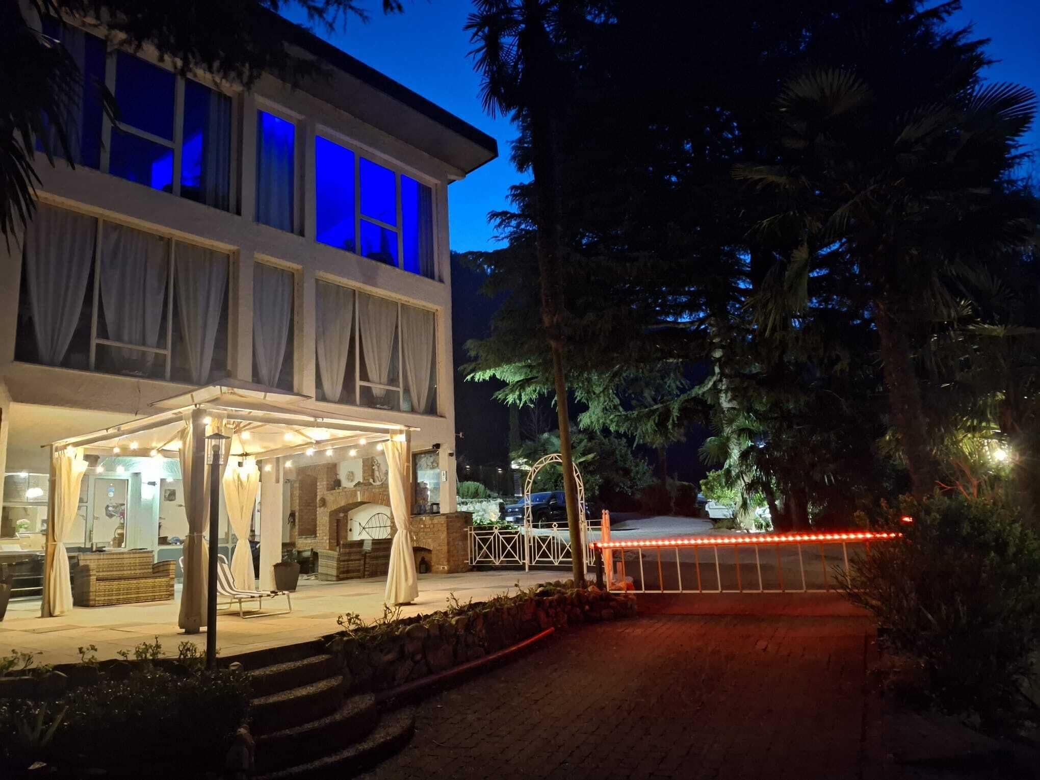A two-story building with a covered outdoor seating area and a gated entrance.
