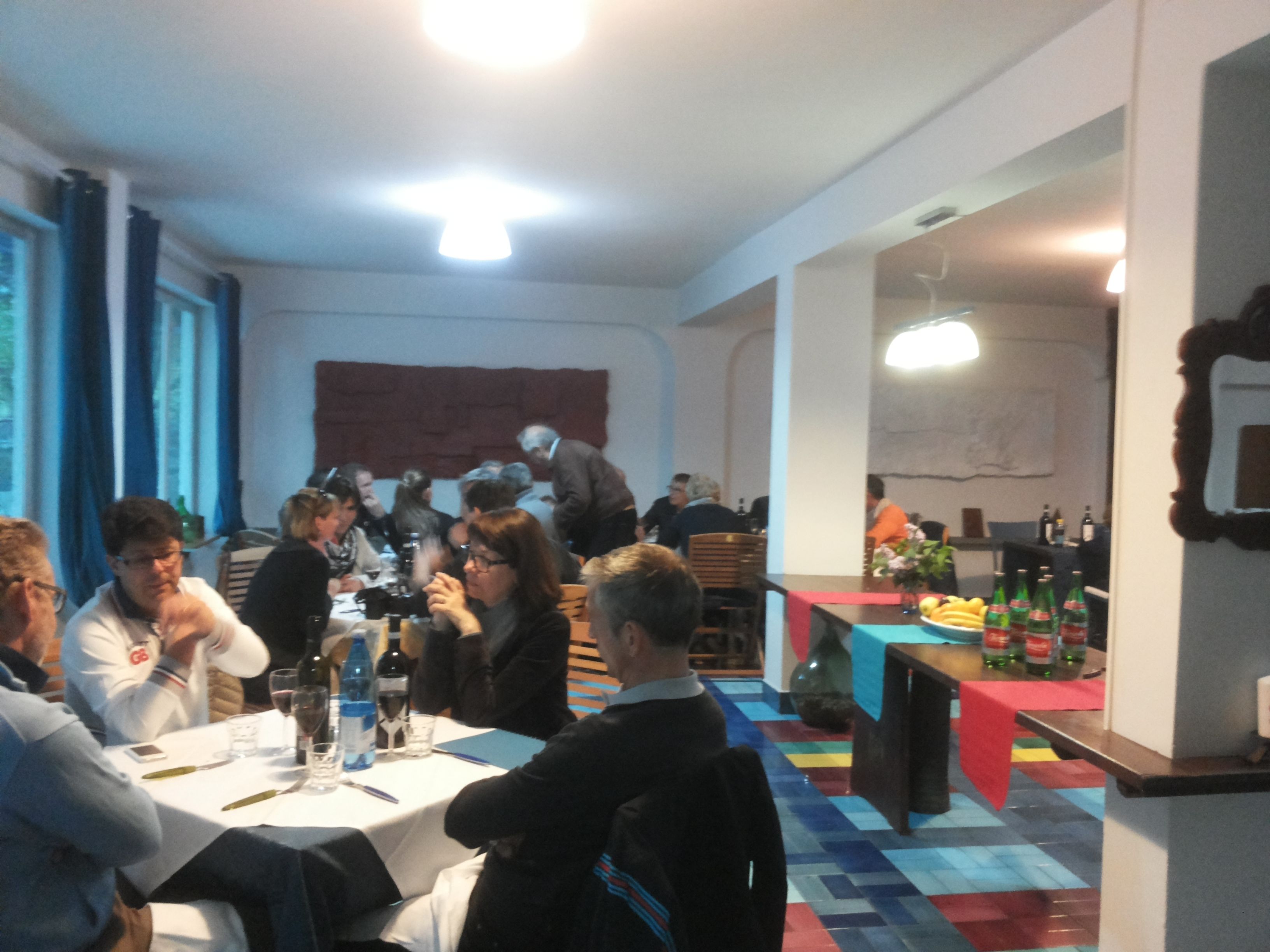 Ein Konferenzraum mit runden Tischen, Stühlen und einer Bar mit Flaschen.
