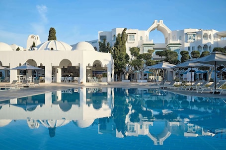Una piscina al aire libre, sombrillas, sillones reclinables de piscina. The Mirage Resort & Spa