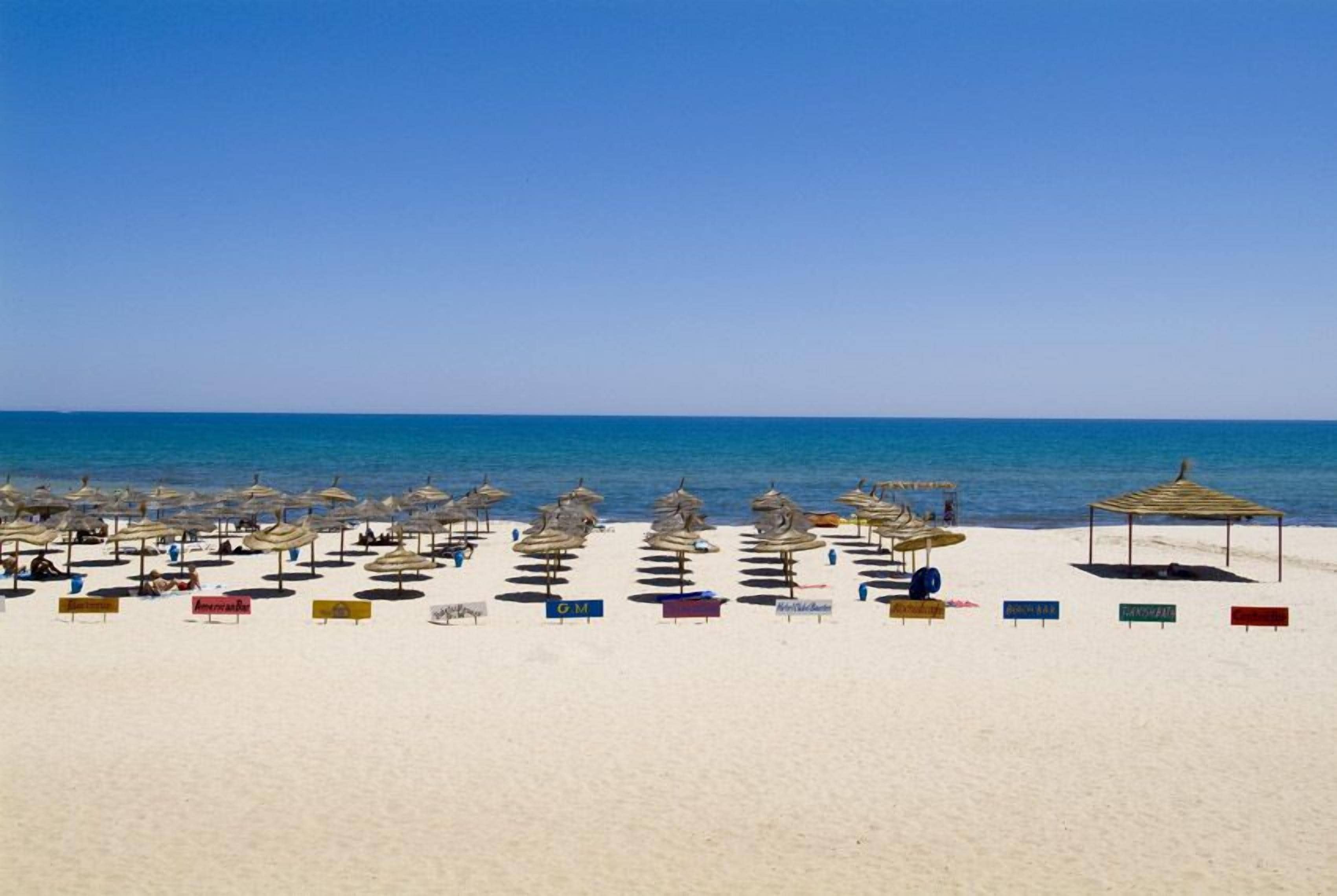 On the beach, white sand, sun-loungers, beach umbrellas