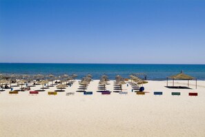 Accommodatie ligt op het strand, wit zand, ligstoelen, parasols