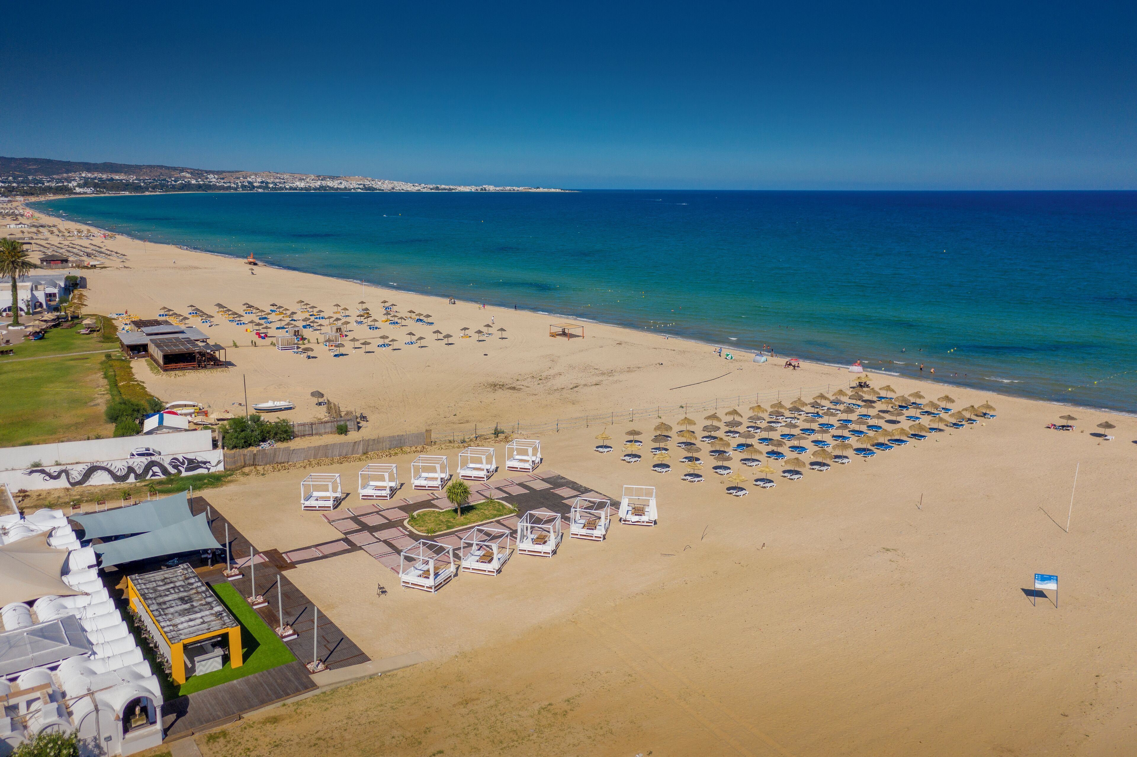 On the beach, white sand, sun-loungers, beach umbrellas
