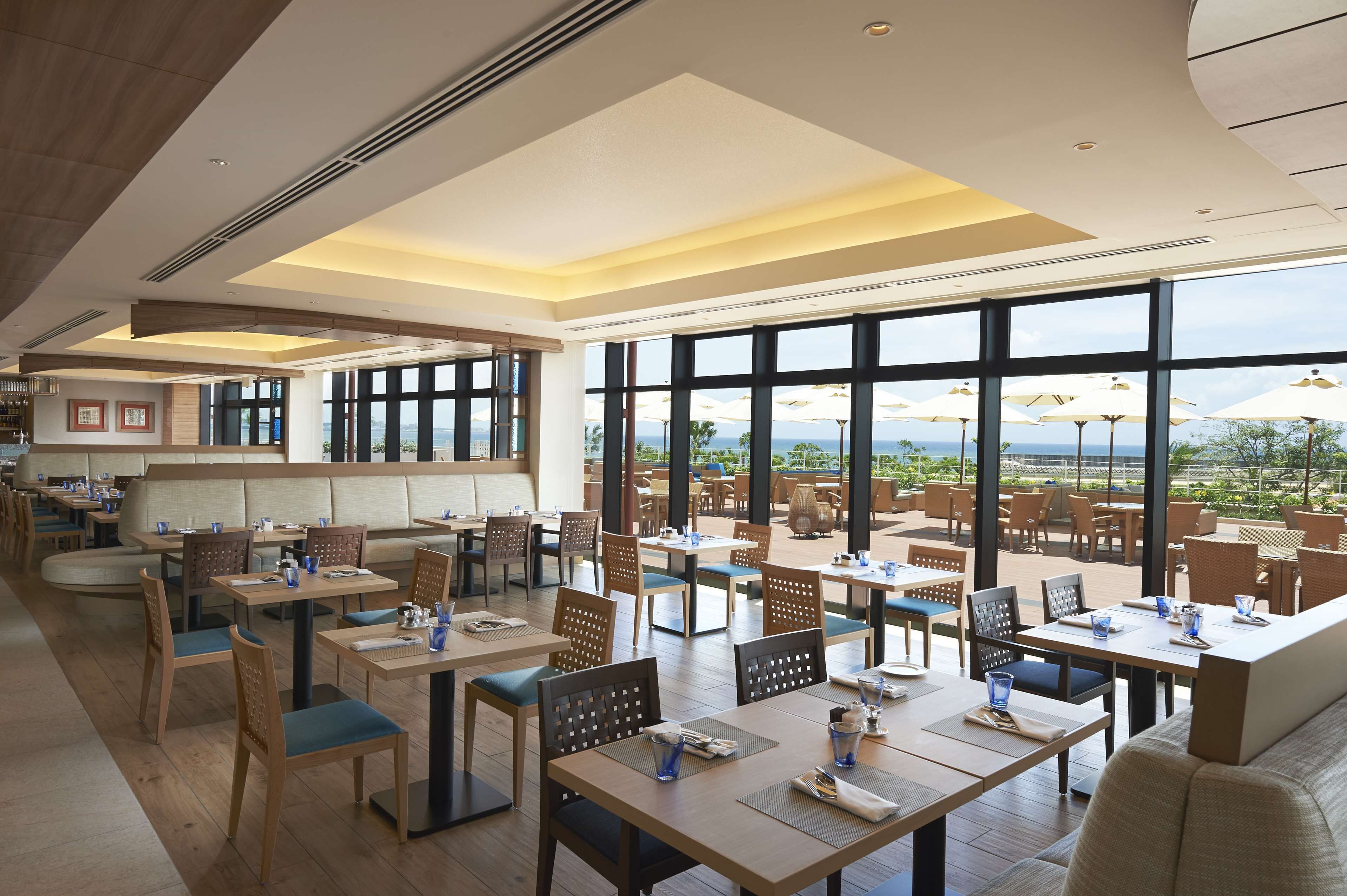 A spacious restaurant with high ceilings, large windows, and a view of the outdoors.