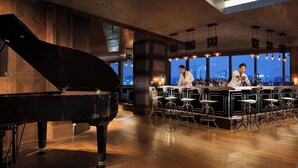 A bar area with a grand piano, a bar counter, and multiple stools. - JW Marriott Dongdaemun Square Seoul (Seoul)