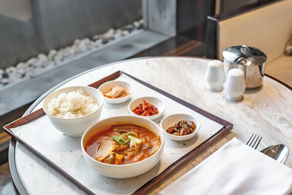 A meal tray with rice, kimchi, and a bowl of soup on a marble table. - JW Marriott Dongdaemun Square Seoul (Seoul)