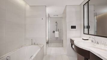 Un baño moderno con bañera, ducha y tocador con espejo.