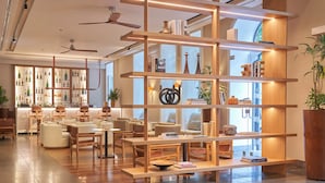 A modern interior with wooden shelves, seating, and a bar area. - PortoBay Liberdade (Lisbon)