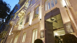 Un edificio histórico con arquitectura ornamentada, ventanas amplias y una entrada destacada.